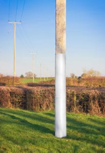Polesaver fire fabric shown on a wooden utility pole in field